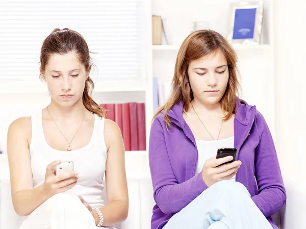 Twee tiener girs met mobiele telefoons — Stockfoto