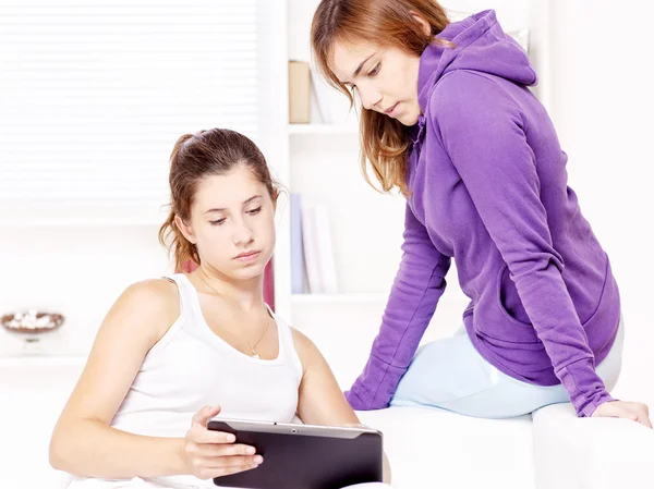 Две девочки-подростки используют планшетный компьютер — стоковое фото