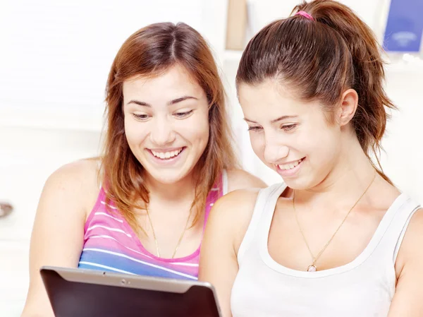 Дві щасливі дівчата-підлітки використовують сенсорний комп'ютер — стокове фото