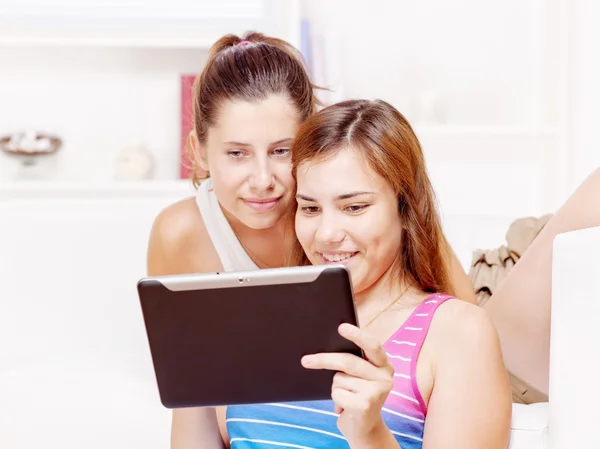 Dos niñas adolescentes felices usando el ordenador táctil —  Fotos de Stock
