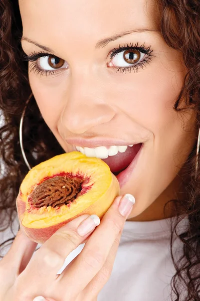 Woman eating peach — Stock Photo, Image