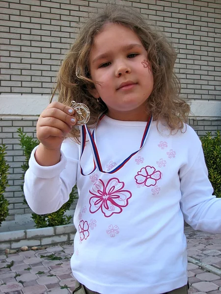 Girl with golden medal — Stock Photo, Image