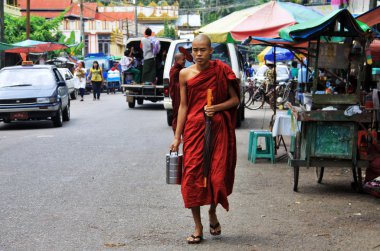 Young monk walking in Yangon with offering lunch clipart