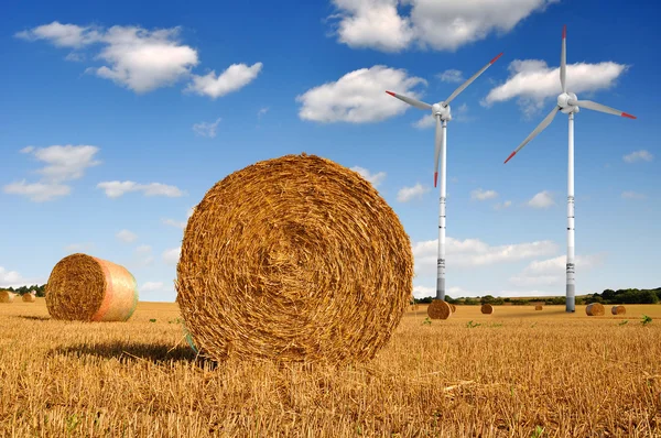 Balle di paglia su terreni agricoli con turbina eolica — Foto Stock