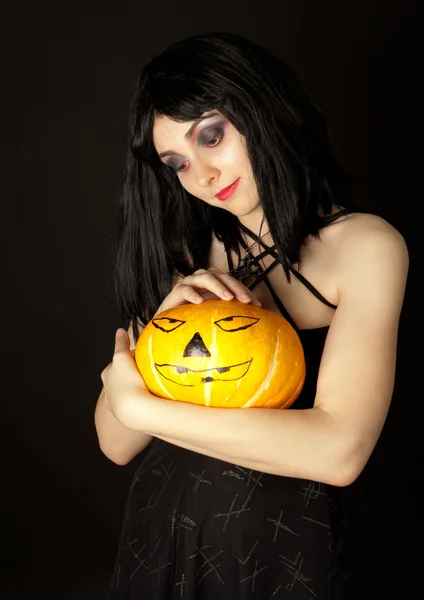 Cizí žena v šatech drží halloween dýně — Stock fotografie
