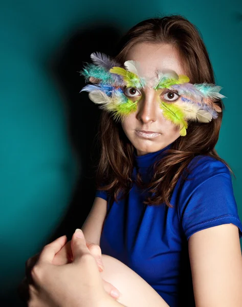 Girl with colorful feather on her face — Stock Photo, Image