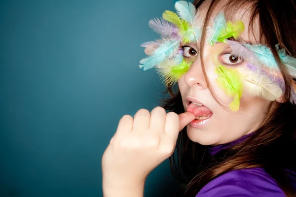 Dziewczyna z kolorowych piór na jej twarzy — Zdjęcie stockowe