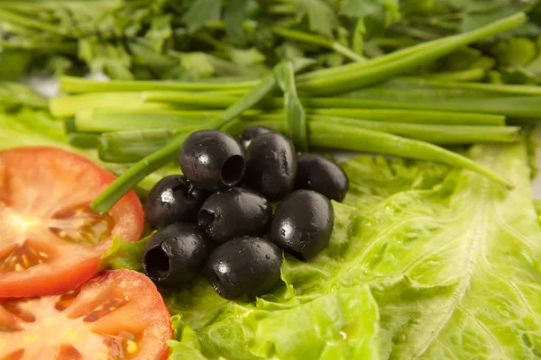 Тарілка з нарізаними помідорами, оливками, салатом — стокове фото