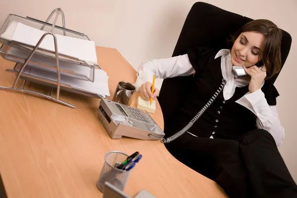 通过电话在办公室打电话的女商人 — 图库照片