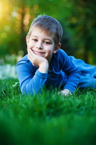 Милий хлопчик лежить на траві — стокове фото