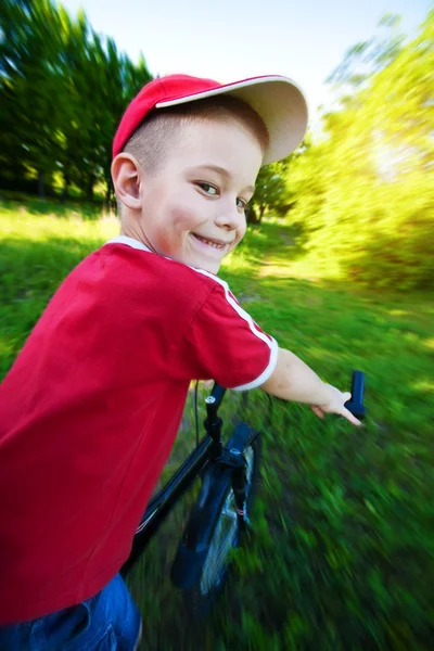 Menino feliz monta uma bicicleta — Fotografia de Stock