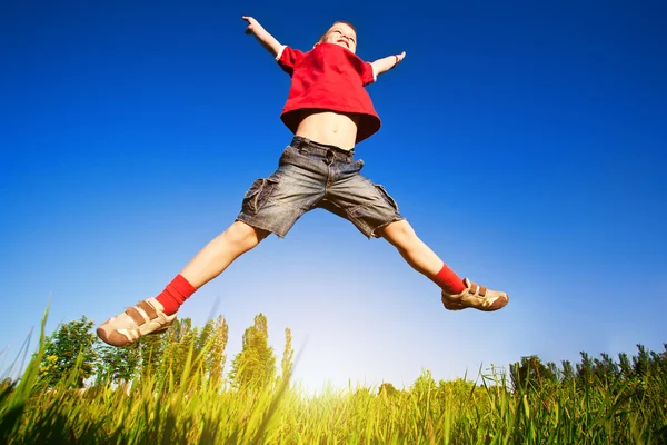 Garçon sautant contre le ciel bleu — Photo