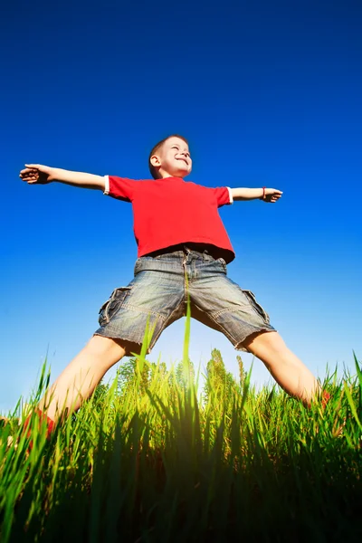Мальчик стоит на фоне голубого неба — стоковое фото