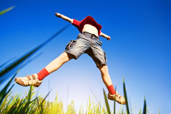 Çocuğa karşı mavi gökyüzü atlama — Stok fotoğraf