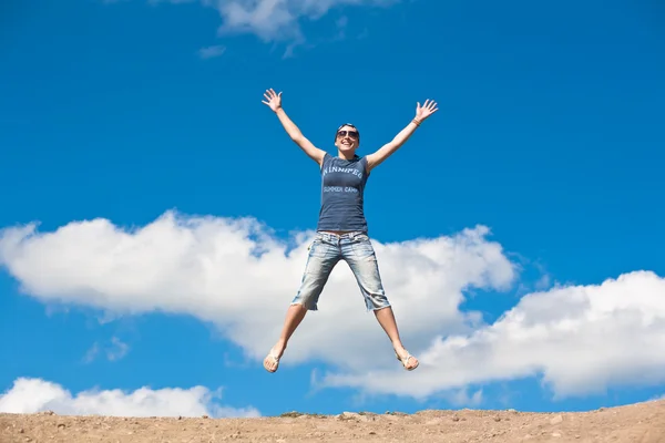 Jumping girl with hands up against — Stock Photo, Image