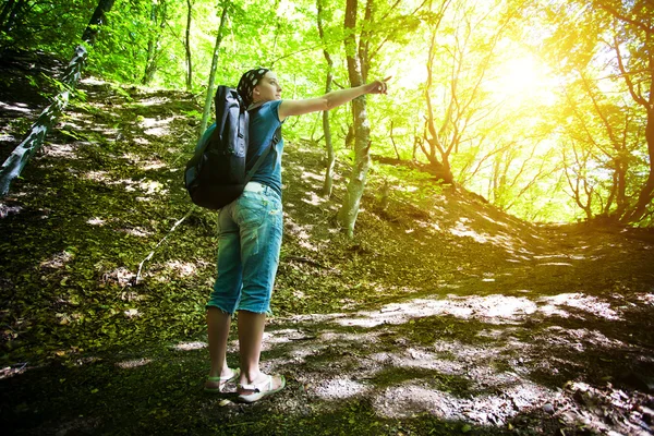 Mladá dívka ukazuje cestu v lese — Stock fotografie