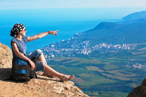 Young tourist looks for way from the rocks top — Stock Photo, Image