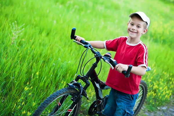 Хлопчик веде свій велосипед на стежці — стокове фото
