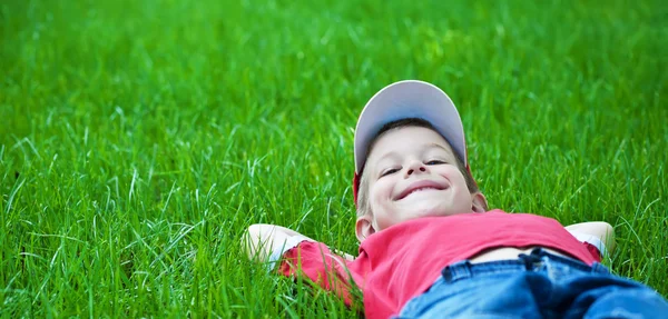 Junge auf Gras liegend. Familienpicknick im Frühlingspark — Stockfoto