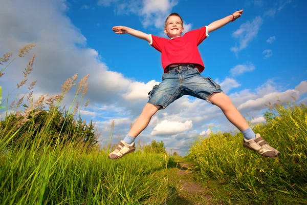 Chlapec skákání proti modré obloze — Stock fotografie