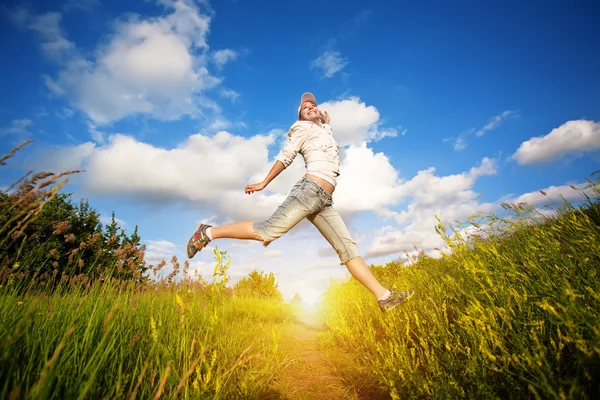 Szczęśliwa kobieta skoki nad niebieski niebo — Zdjęcie stockowe