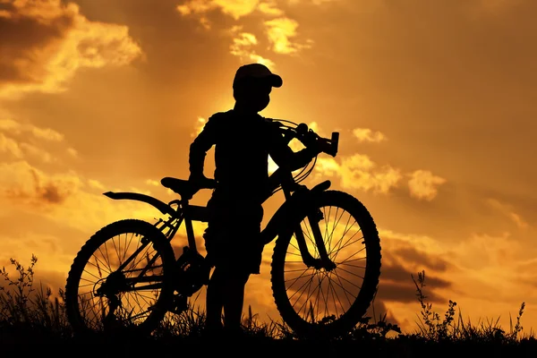 Sylwetka rowerzysta na pomarańczowe niebo — Zdjęcie stockowe