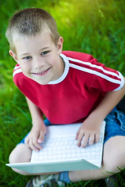 Zes jaar oude jongen zitten met een laptop — Stockfoto