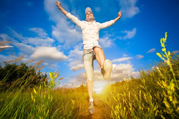 Glad tjej som hoppar över den blå himlen — Stockfoto