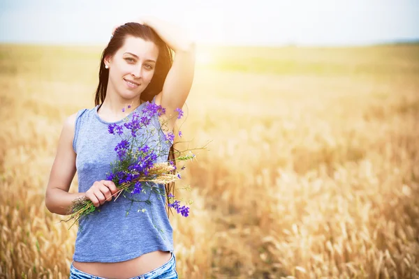 Flickans porträtt med vilda blommor — Stockfoto