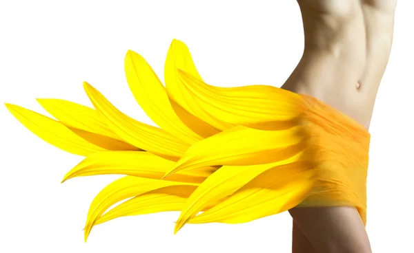 Schöne Frau mit Sonnenblumenblättern auf den Hüften — Stockfoto