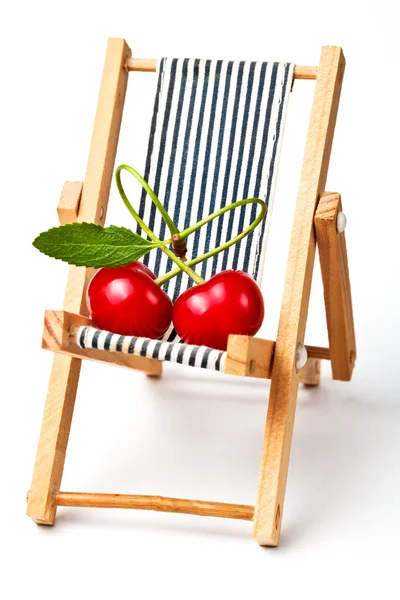 Couple in love.red cherryes on the beach chair — Stock Photo, Image