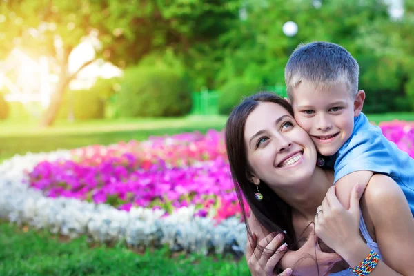Mother and son siting on grass — Stock Photo, Image