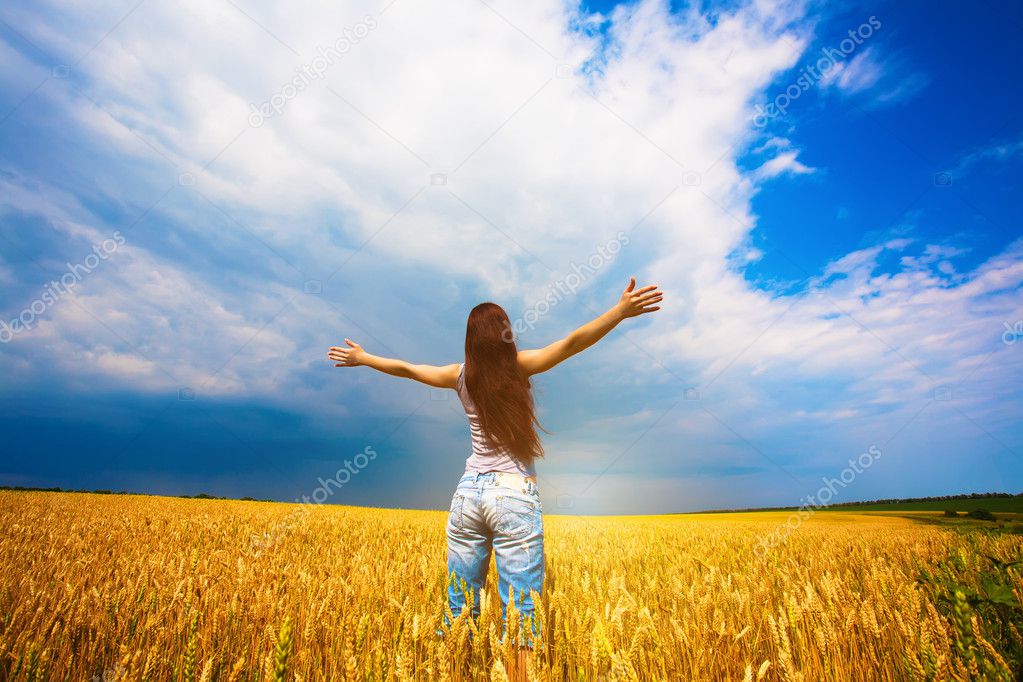 Girl with outstretched arms is enjoys summer day