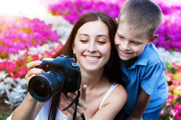 Mãe e filho estão tirando fotos na flor — Fotografia de Stock