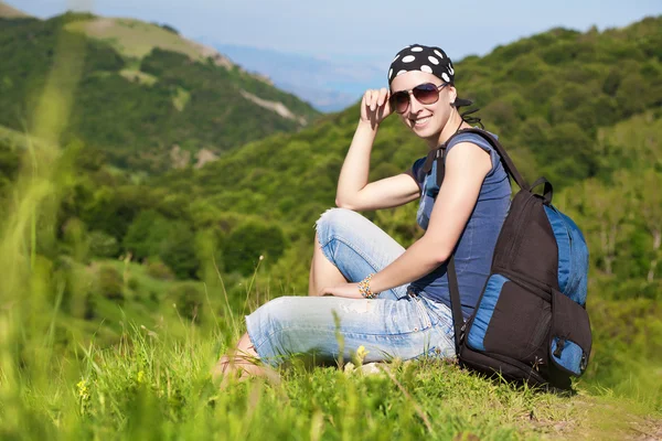 Girl is resting sitting on the grass in mountains — Stock Photo, Image