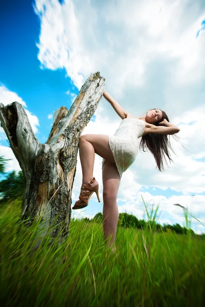 Attractive girl is posing with a stump — Stock Photo, Image