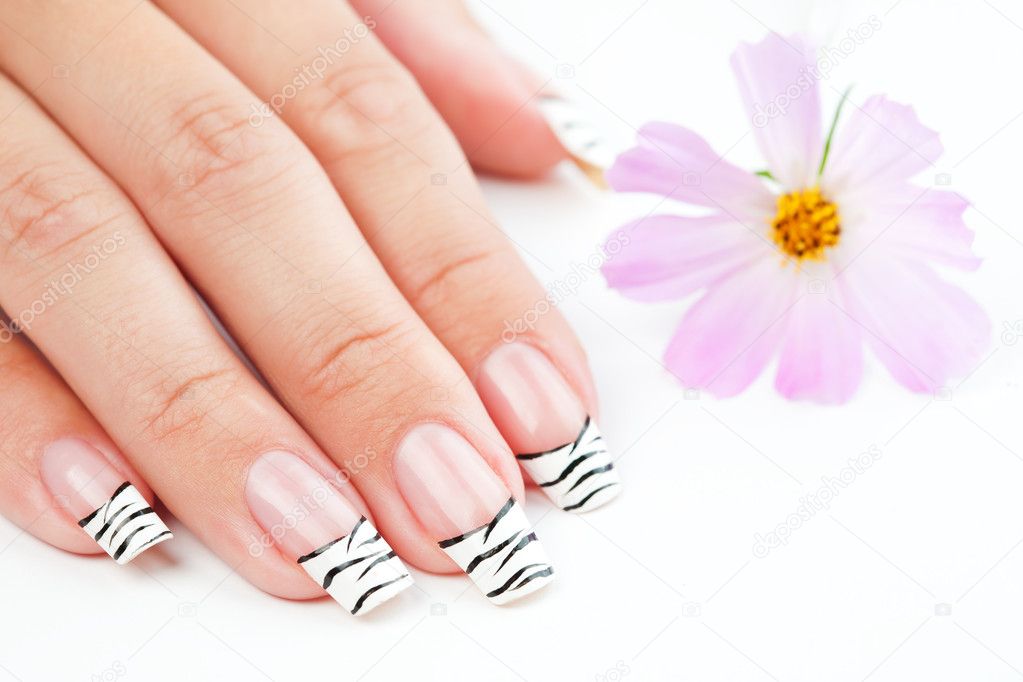 Hands with striped manicure relaxing with flowers