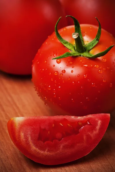 Tomates vermelhos em uma placa de corte — Fotografia de Stock