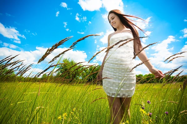 Chica morena en un prado verde en flor — Foto de Stock