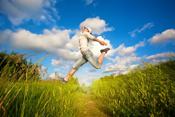 Frau springt über den blauen Himmel — Stockfoto