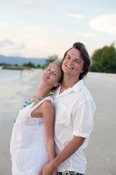 Casal atraente se divertindo na praia do pôr do sol — Fotografia de Stock
