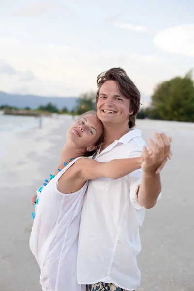Приваблива пара розважається на пляжі заходу сонця — стокове фото