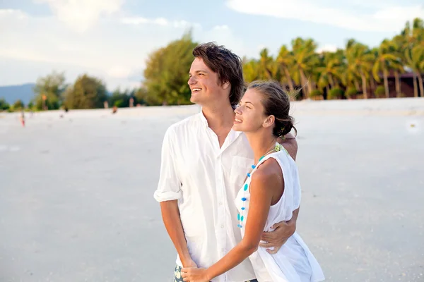 Couple attrayant s'amusant sur la plage du coucher du soleil — Photo