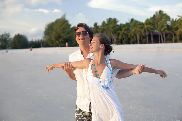 Привлекательная пара, развлекающаяся на пляже на закате — стоковое фото