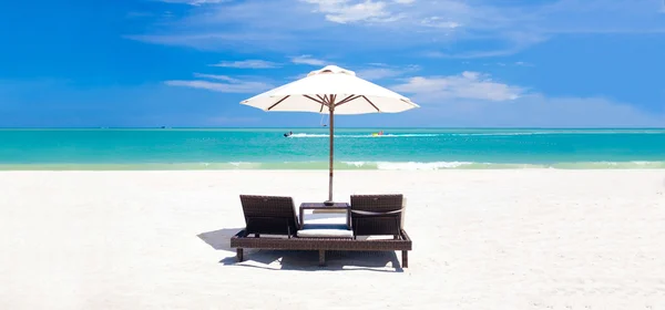 Panoramic view of umbrella and two chairs on a tropical beach — Stock Photo, Image