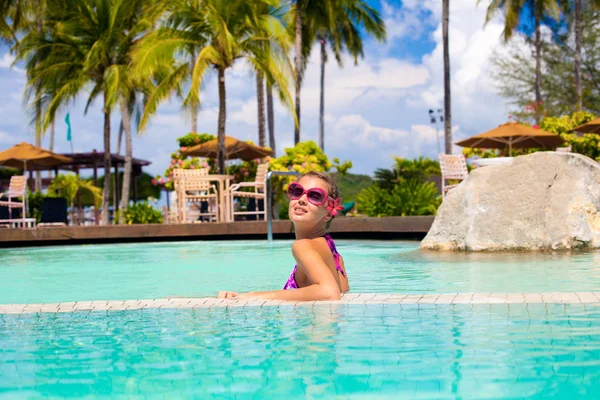 Krásná mladá žena v sluneční brýle v bazénu — Stock fotografie