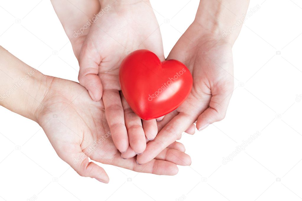 Two pairs of hands carefully holding red heart