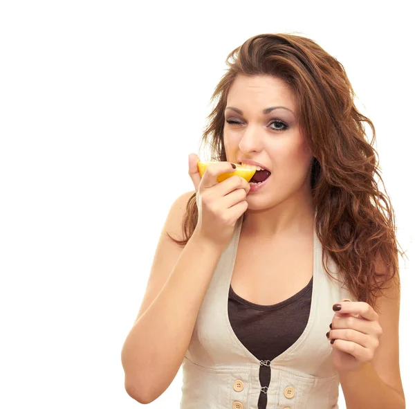 Девушка кусает лимон — стоковое фото