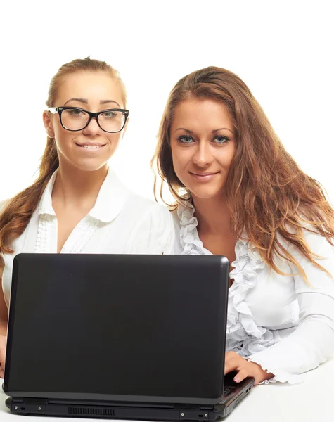 Две улыбающиеся девушки с компьютером — стоковое фото