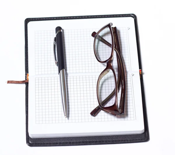 Ноутбук с ручкой и очками — стоковое фото